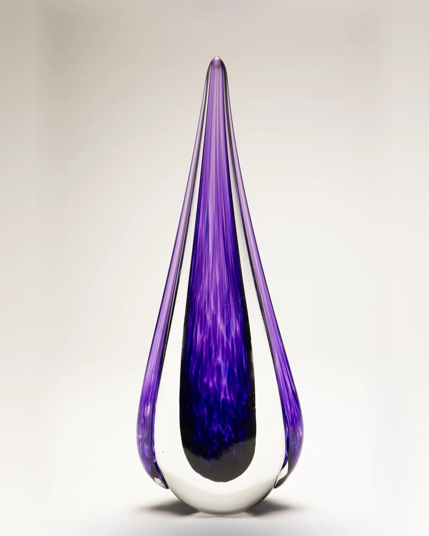 Solid violet glass teardrop award with clear outer layers on a white backdrop