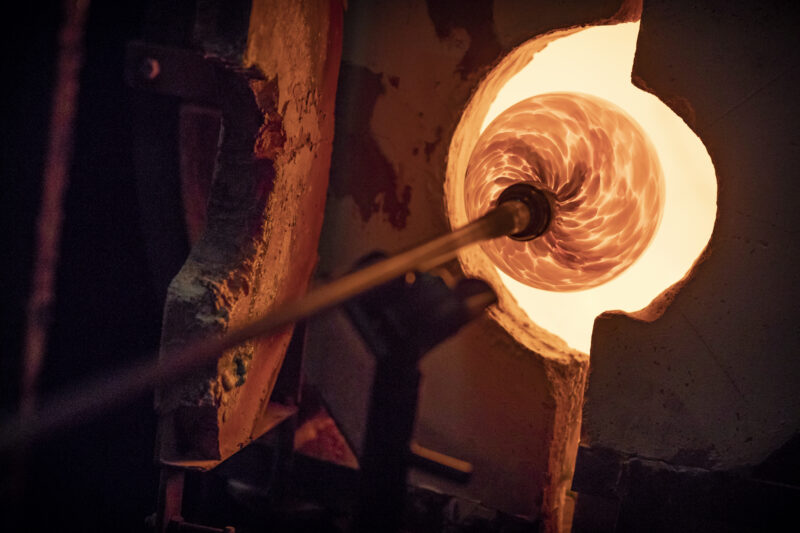 Image shows glass in a glassblowing oven.